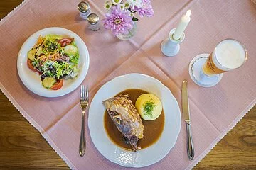 Gaststube, gedeckter Tisch von oben fotografiert mit Schäufele, Kloß, Salat und Weizen