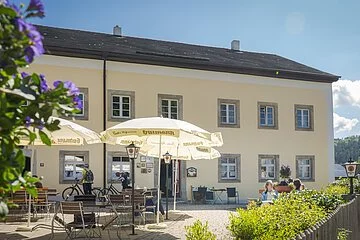 Aussenansicht mit Biergarten und Sonnenschirmen