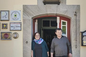 Ehepaar Hollberg, Wirtsleute stehen im Türbogen am Eingang ihres Gasthofes