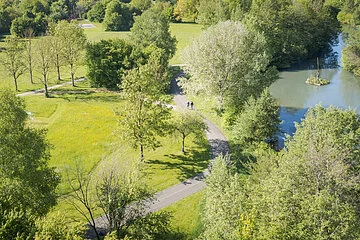 Luftaufnahme der Altmühl durch den Kurpark. In der Ferne laufen zwei Personen auf dem Weg.