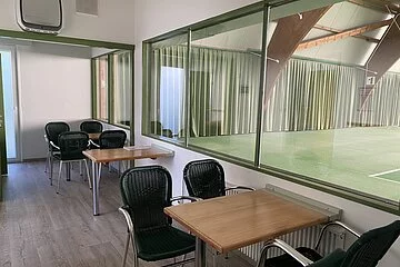 Aufenthaltsbereich in der Tennishalle Treuchtlingen mit Blick auf die Spielfelder