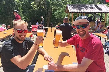 Zwei Herren prosten sich zu auf der Sonnenterrasse der Talstation Heumöderntal
