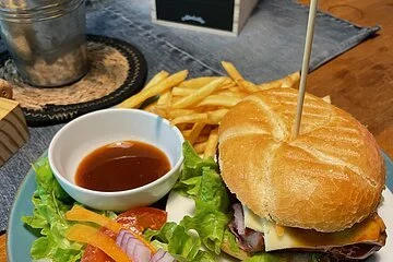 Burger mit Pommes und Salat in der Stube der Talstation Heumöderntal