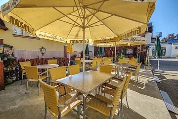 Sitzplätze im Biergarten unter Sonnenschirmen