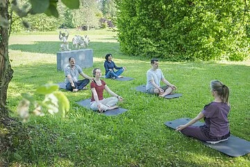 Yoga im Kurpark mit zwei Pärchen und der Yogalehrerin