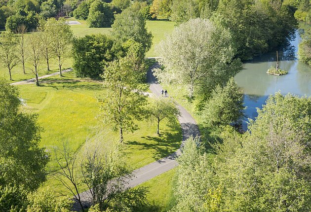 Luftaufnahme der Altmühl durch den Kurpark. In der Ferne laufen zwei Personen auf dem Weg.