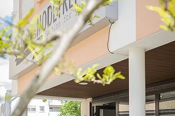 Juttas Modetreff von aussen, Ehepaar mittleren alters auf Shopping-Tour.