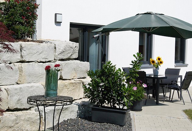 Terrasse mit Sitzgarnituren und Sonnenschirm
