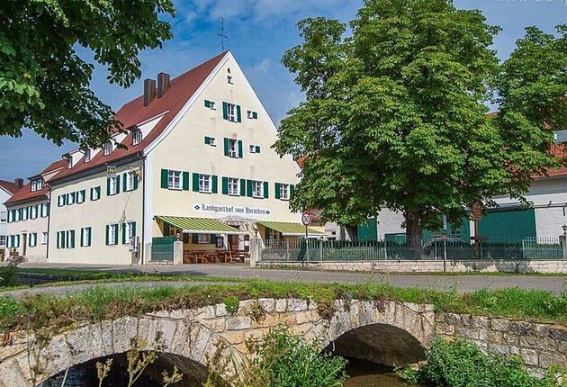 Der Bach Rohrach und die Brücke im Vordergrund, im Hintergrund der Gasthof mit einem großen Baum