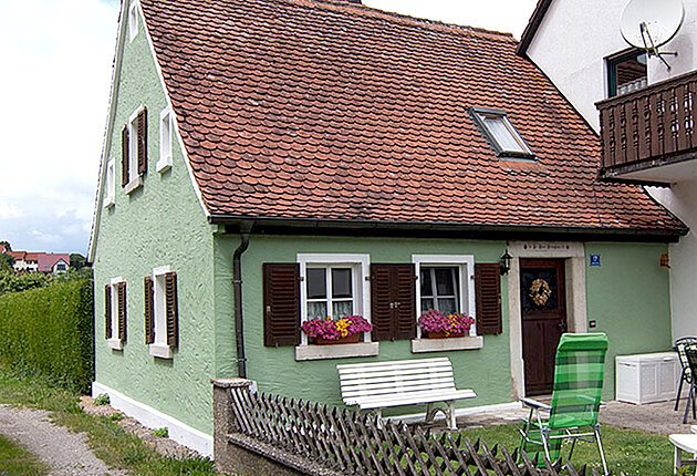 Ferienhaus in grünem Anstrich mit kleinem Vorgarten