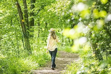 Spaziergängerin schlendert durch den grünen Wald