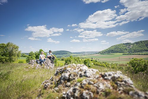 Pärchen sitzt auf dem Bubenheimer Berg und schaut in die Ferne.