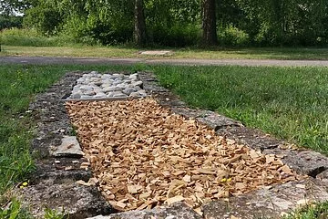 Ein Element des Barfußpfades im Kurpark mit Hackschnitzeln und Steinen