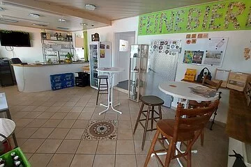 Verkaufsraum von Feine Biere, auf der linken und rechten Seite stehen Kühlschränke mit zahlreichen Biersorten. Im Hintergrund befinden sich Stehtische.