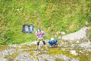 Zwei Kletterer mit professioneller Ausrüstung erklimmen eine Wand des Klettersteinbruchs bei Möhren.
