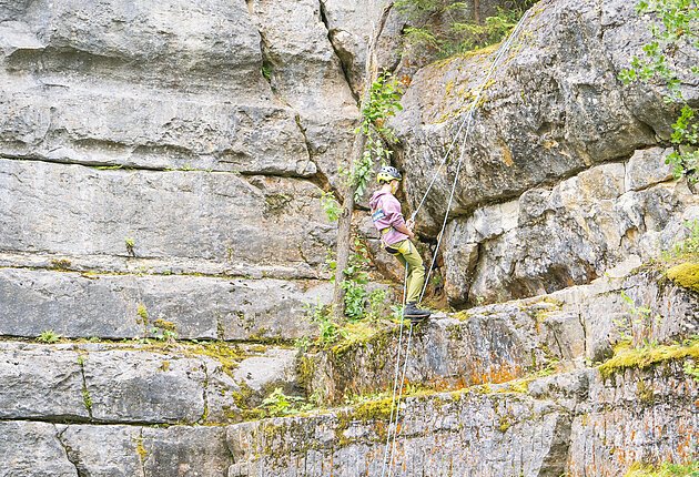 Frontaufnahme eines Kletter-Hangs am Steinbruch Möhren. Ein Kletterer erklimmt mit professioneller Ausrüstung die Steinwand im Hintergrund.