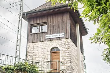Ein älteres Ehepaar schaut vom Gehsteig aus nach oben auf das Alte Stellwerk 2