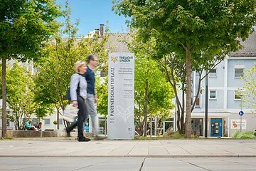 Partnerschaftsplatz mit Spaziergängern