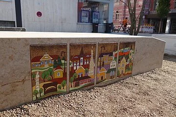Vier Emaille-Tafeln, die den Bonyháder Marmorblock zieren, wurden vom heimischen Künstler Stekly Zsuzsa gestaltet und zeigen die wichtigsten Gebäude von Bonyhád.