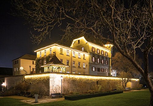 Romantisch beleuchtetes Stadtschloss mit Schlossgraben