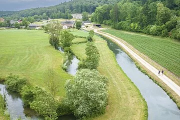 Drohnenaufnahme des Möhrenbachtals. Blick über die weite Landschaft, durch die der Möhrenbach in natürlichem Flussbett mäandriert.