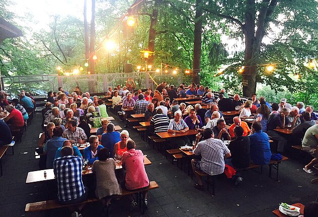 Gäste an den Biertischen auf der Terasse Wettelsheimer Keller