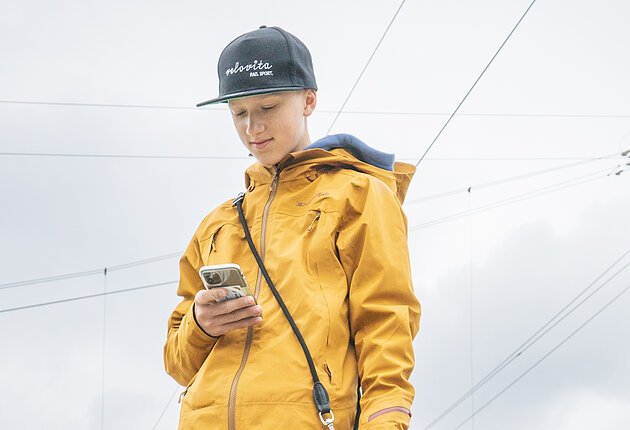 Aufnahme eines Treuchtlinger Bahnsteigs. Im Hintergrund sind zwei DB Regionalzüge zu sehen. Im Vordergrund steht ein Junge mit seinem Hund und blickt in sein Smartphone.