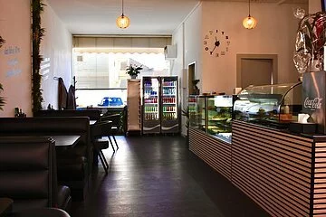 Theke mit Speisenauswahl sowie Sitzmöglichkeiten mit schöner Dekoration.