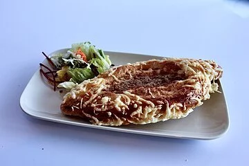 Eine Pide auf Teller angerichtet mit Salatgarnitur