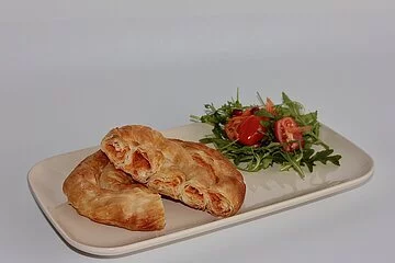 Ein Börek auf Teller angerichtet mit Salatgarnitur