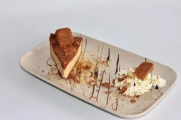 Ein Teller mit Lotus Cheescake mit Sahnehaube