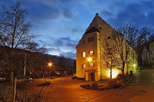 Auf dem Bild ist eine Seitenansicht des Kulturzentrum Forsthaus in Treuchtlingen bei Nacht zu sehen.