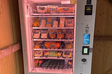 Weißer Verkaufsautomat für Wurstwaren, Grillspezialitäten, Getränken und Baguette.