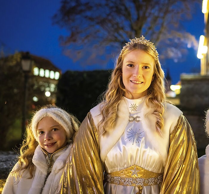 Das Treuchtlinger Christkind mit blonden Locken und Krone, daneben die beiden Engel mit weißen Stirnbändern